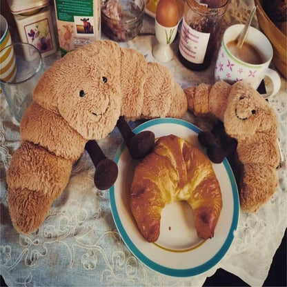 SnuggleCrumb™ – Smiling Croissant Plush Toy – Soft Cuddly Pillow